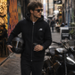 Rider wearing the Guardian kevlar motorcycle hoodie with helmet and coffee in hand