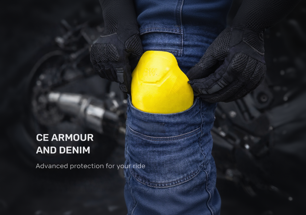 Person wearing black gloves and blue jeans holding a yellow object with motorcycle parts in the background, promoting CE Armour and Denim.